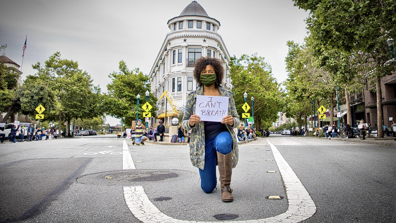 Joy Flynn, community organizer, kneels while holding an “I Can’t Breathe” sign on May 30, 2020 in downtown Santa Cruz, memorializing the last words spoken by 46-year-old George Floyd just before he was murdered by Minneapolis police officer Derek Chauvin.