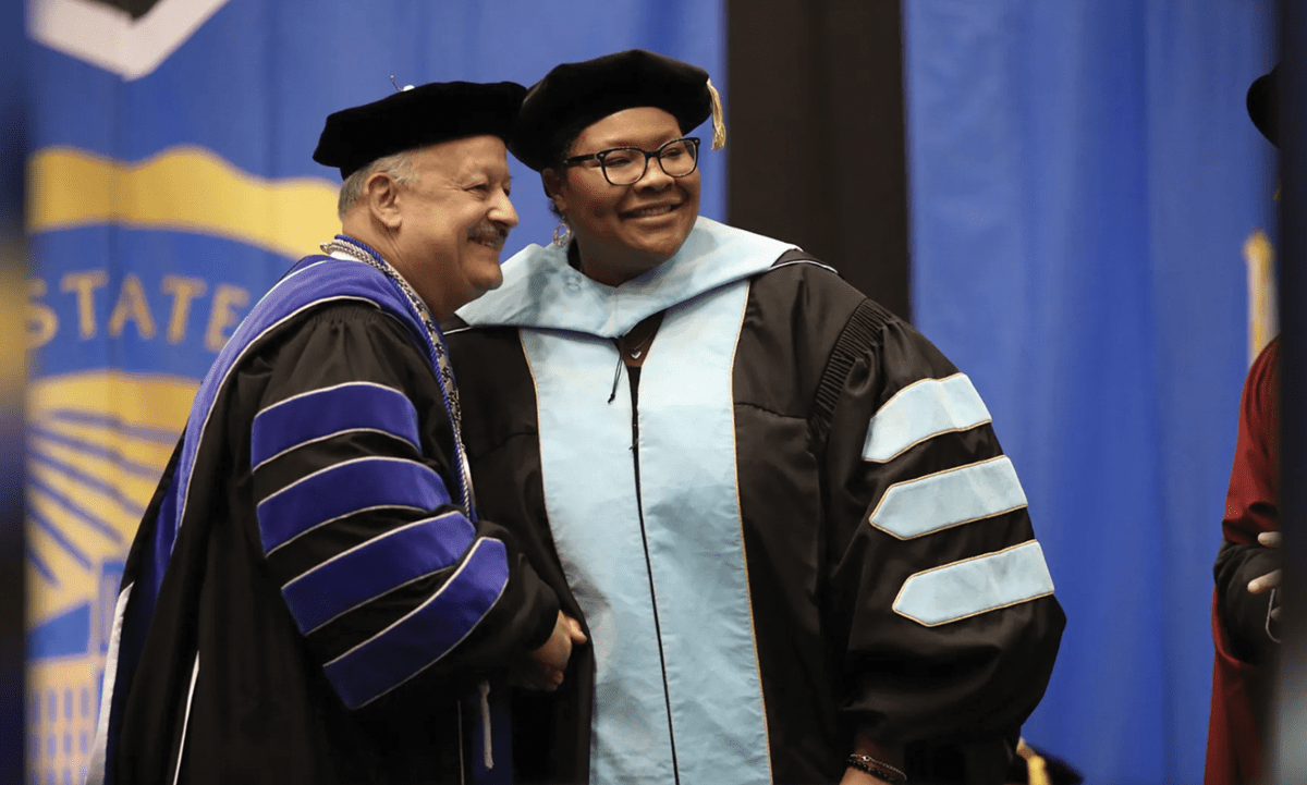 Cherina Betters (right) is congratulated by CSUSB President Tomás D. Morales upon receiving her Ed.D. degree.