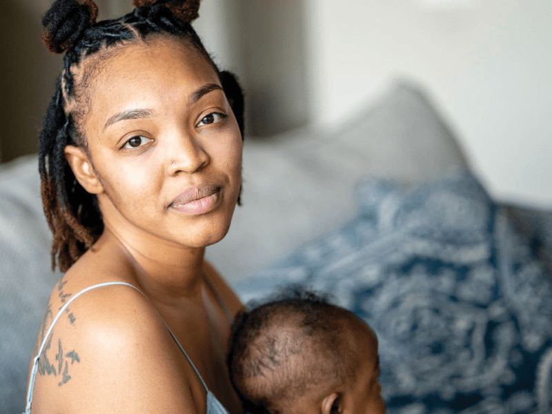 Jessica Mabson poses for a portrait while holding her four month old son, Ennis, on April 5, 2023. Jessica is a 31-year-old midwife student, veteran, mother of two, wife, and educator. As a babywearing educator, Jessica is trained in methods that help parents learn techniques for hands-free carrying and bonding with the baby. “I am very big on reproductive justice — that is my jam,” Jessica said. “My work brings me joy, being able to bring accessibility to people of the global majority is really what does it for me; being able to educate people on options they have as far as birth and locations [for birthing] that people are not aware they have.”