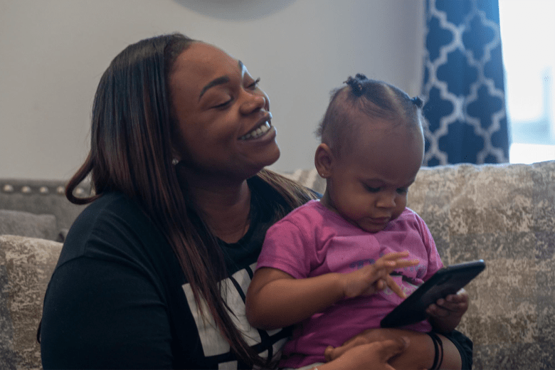 Mackenzie holds her daughter Mia as she listens to her husband Malcolm share his joy of fatherhood on April 5, 2023. “I’m new to this, and I guess I didn’t realize the intense feeling of joy that it brings you. I enjoy it all, even the hard times, because definitely there are,” Mackenzie said.