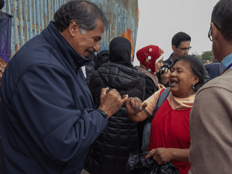 Attendees of the Border Church and Border Mosque interfaith service give pinkie kisses during the close of a Sunday interfaith service on December 22, 2019. The binational park has long been known as a place for reunification and community. The U.S. side of the park was closed in 2020.